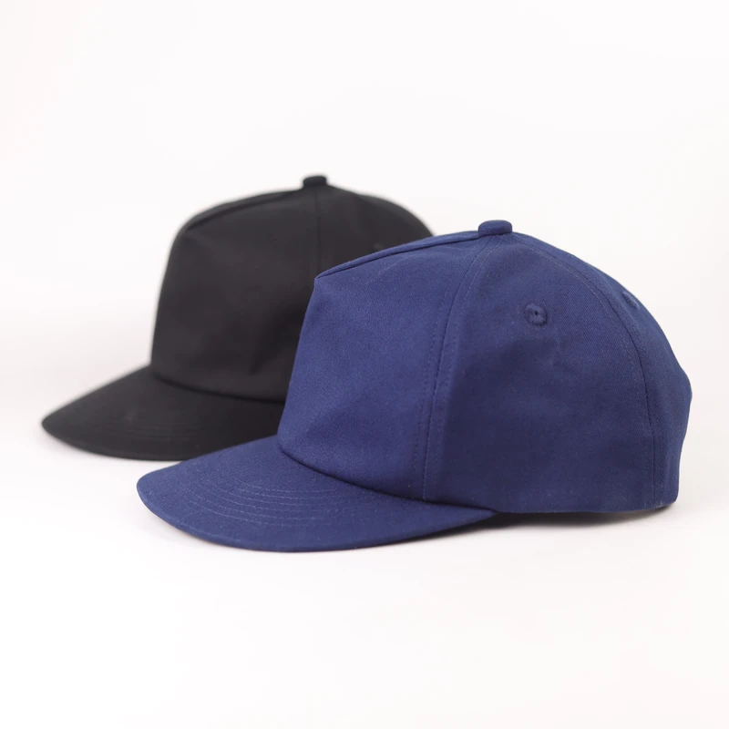 Navy and black cotton short-peak caps compared from a front side angle
