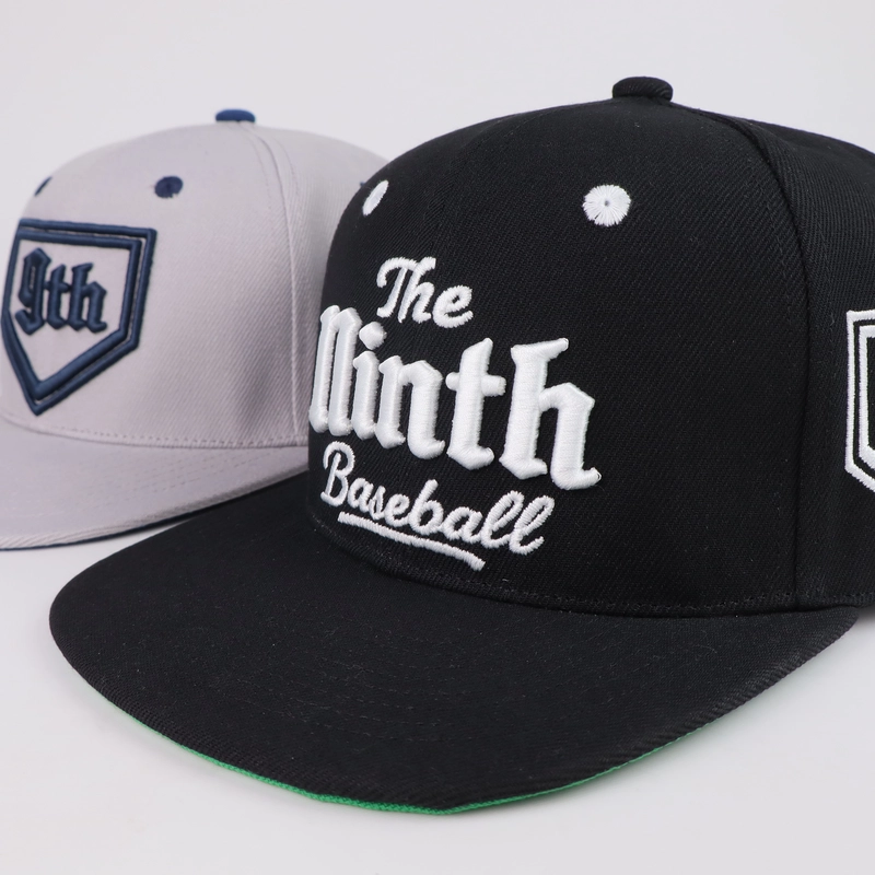Black cap with dimensional white lettering beside a separate light grey cap