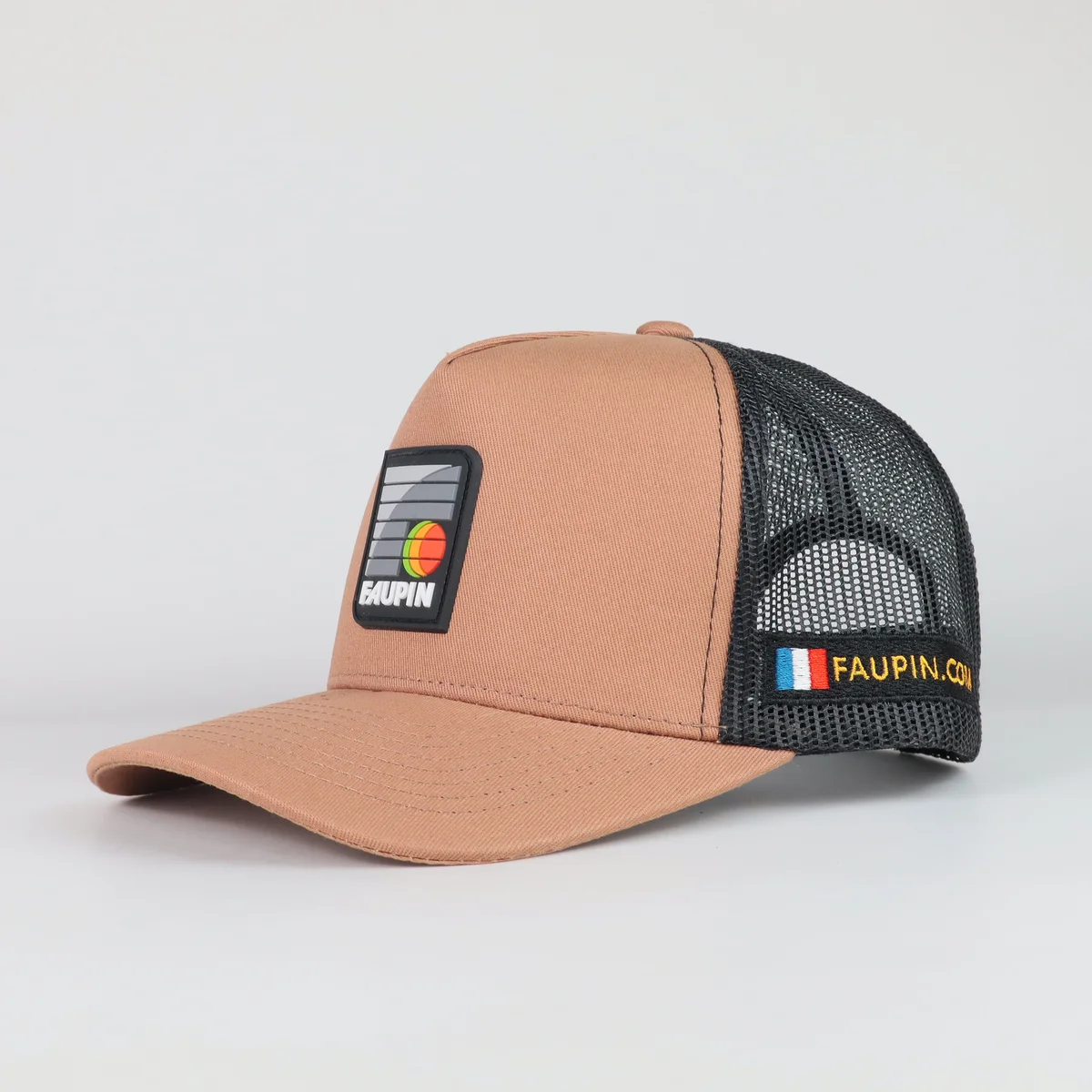 Tan-front trucker cap with rectangular patch, black mesh and a side label
