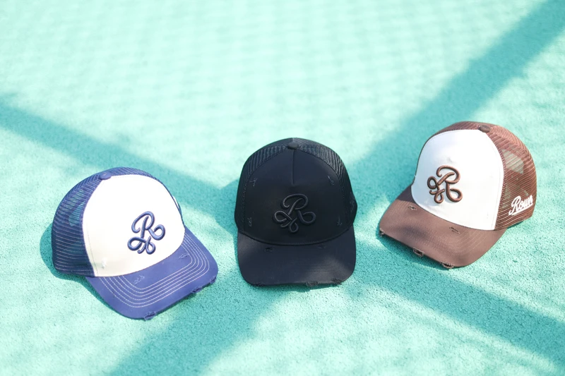 Three cap colors in outdoor sports setting showing mesh and raised-looking embroidery