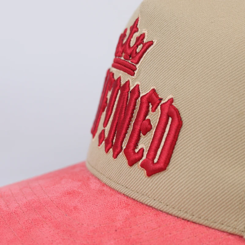 Close-up of red raised-looking front embroidery on khaki cap
