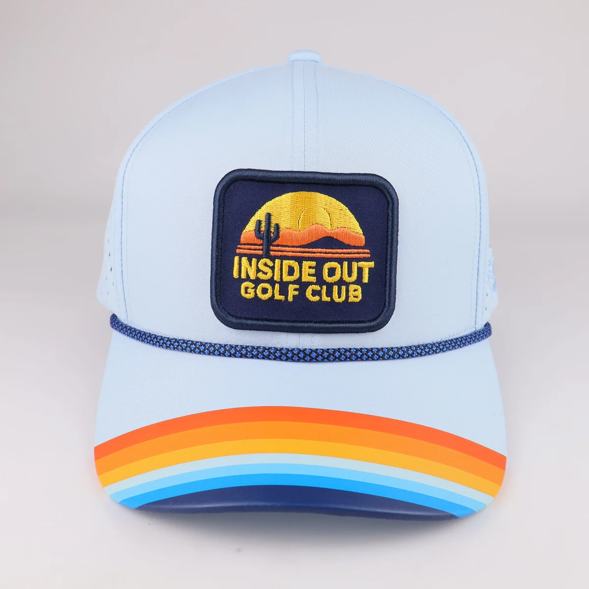 Light blue cap with dark visor rope, rectangular front patch and multicolor visor bands
